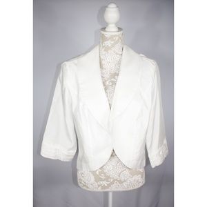 A shiny polyester white top that pairs well with a sleeveless dress or top